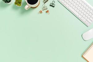 minimalt arbetsutrymme - kreativt plattläggningsfoto av arbetsytans skrivbord. ovanifrån kontorsbord med tangentbord och mus på pastellgrön bakgrund. ovanifrån med kopieringsutrymme, plattfotografering. foto