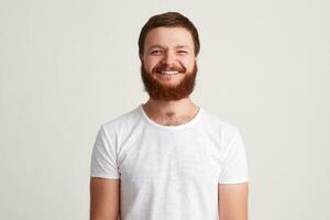 porträtt av glad attraktiv ung man med skägg bär t skjorta foto