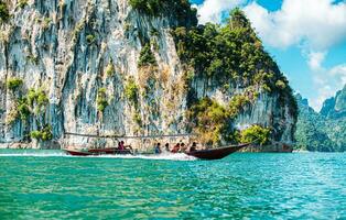 khao sok nationell parkera, surat än mig, landskap bergen med lång svans båt för resenärer, tugga lan sjö, ratchaphapha damm, resa natur i thailand, Asien sommar semester resa resa. foto