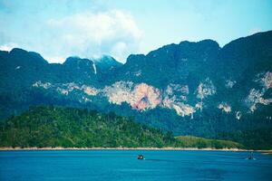 khao sok nationell parkera, surat än mig, landskap bergen med lång svans båt för resenärer, tugga lan sjö, ratchaphapha damm, resa natur i thailand, Asien sommar semester resa resa. foto