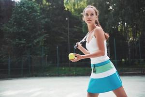 kvinna i sportkläder serverar tennisboll. foto