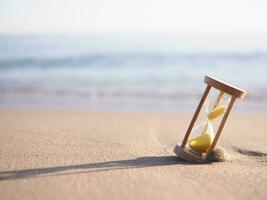 timglas på de strand i de solnedgång tid. de begrepp handla om nedräkning till sommar, resa, semester och avslappning. foto