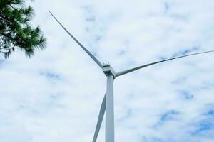 väderkvarn för elektrisk kraft produktion med skön landskap och blå himmel till generera rena förnybar grön energi för hållbar utveckling. foto