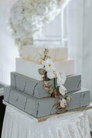 bröllop kaka dekorerad med reste sig blommor i fyra tiers isolerat på vit bakgrund foto