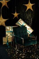 gyllene stjärnor hängande på en mörk bakgrund, ny år gåvor i guld omslag, en grön stol på en mörk bakgrund foto