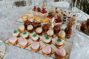 festlig efterrätt tabell med sötsaker. bröllop godis bar, olika kakor, choklad på står. foto