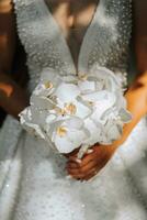 bröllop i europeisk stil. porträtt av de brud i en klassisk stil, vit klänning, bukett av orkide blommor. foto