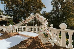 modern ceremoni i europeisk stil. bröllop båge med ro på de bakgrund av de skog. Smycken tillverkad av färsk blommor, blommor och kristaller. främre se. foto