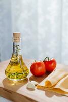 oliv olja, tomat, vitlök och oregano på en trä- styrelse foto