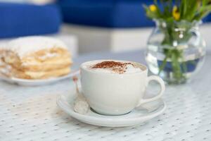 cappuccino med grädde i en vit kopp på de tabell foto