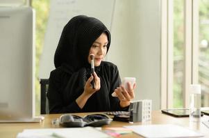 arabisk affärskvinna som bär hijabarbete på kontoret foto