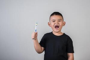 liten pojke som borstar tänderna i studiofoto foto