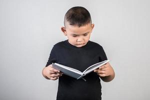 rolig pojke som läser en bok foto