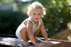 vacker baby pojke i barn trädgård poserar fotograf foto