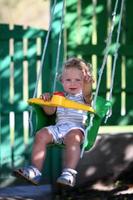 vacker baby pojke med barn swing poserar fotograf foto