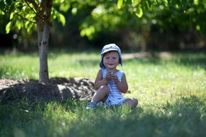 vacker baby pojke i barn trädgård poserar fotograf foto