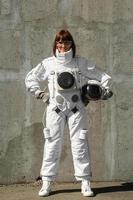 kvinna astronaut utan hjälm på bakgrund av en grå vägg foto