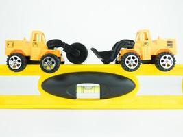 leksakstryck vägbil och bulldozer med byggnadsnivå på vit bakgrund, konstruktionsteknik