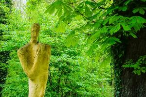 kreativ staty tillverkad av sten i en grön skog nära en kloster foto