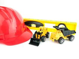 röd skyddshjälm med dumper och bulldozers leksak, konstruktionskoncept foto