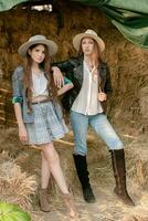 två Tonårs flickor i Land stil kläder Framställ i höloft foto