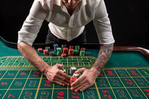 en närbild vibrerande bild av grön kasino tabell med roulett, med de händer av croupier och flerfärgad pommes frites. foto