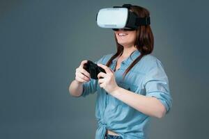 emotionell ung kvinna använder sig av en vr headsetet och upplever virtuell verklighet på grå bakgrund foto