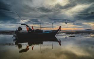 fiske träbåt med solnedgång himmel låg belysning. foto