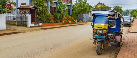 typisk färgglad gammal tuk tuk -rickshaw i luang prabang laos. foto