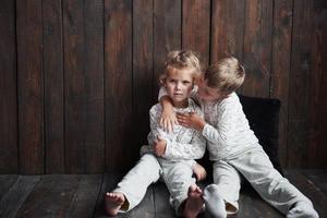 två barn, bror och syster i pyjamas leker tillsammans foto