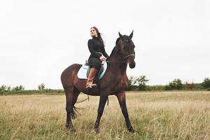 ung vacker flicka - ridning på häst, ridsport under våren foto