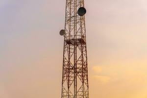 telekommunikation torn antenn och satellit maträtt med kväll himmel bakgrund. foto