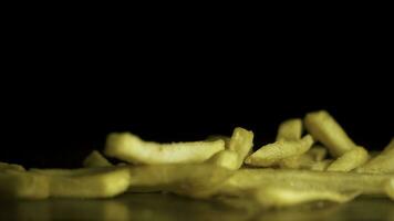 franska frites falla på de tabell isolerat på svart bakgrund. snabbmat. franska pommes frites. flygande friterad potatisar på svart bakgrund. lugg av franska frites över svart bakgrund foto