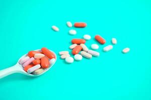 färgrik medicin piller i vit sked på grön tosca bakgrund, tillägg, vitamin, färgrik foto