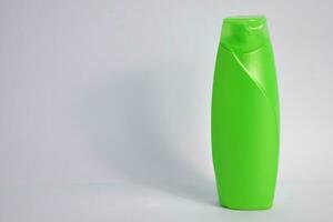 grön tom flaska schampo minimalistisk bakgrund, hår vård flaska falsk upp produkt. foto
