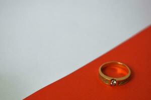 stänga upp gyllene ringa med diamant på diagonal vit och orange bakgrund foto
