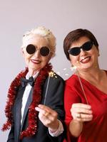 två vackra snygga mogna äldre kvinnor i solglasögon som firar nytt år. kul, fest, stil, firande koncept