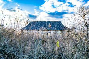 skön gammal övergiven byggnad bruka hus i landsbygden på naturlig bakgrund foto