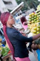 vacker ung kvinna på fruktmarknaden på gatan foto