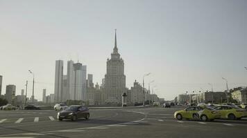 moskva - Ryssland, 2021-08-22. se av ett av underbar sju skyskrapor i moskva designad i de stalinist stil. handling. känd yandex.go taxi service med märkbar gul bilar. foto