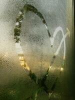 en kärlek hjärta målad på en dimma glas fönster bakgrund foto