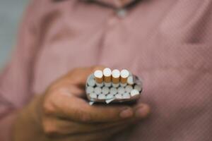 en rökare innehav packa av cigarett för ger annan människor foto