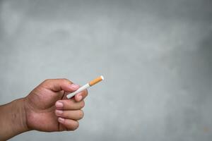 hand innehav cigarett på de fläck bakgrund foto