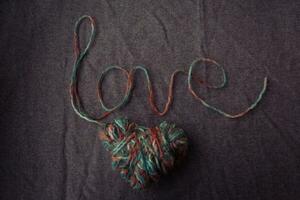 kärlek skriven av ull garn på en brun bakgrund foto