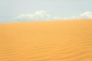 sand dyn i de öken- med moln i de bakgrund. foto