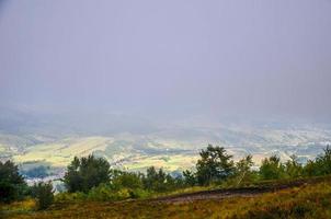 utsikt över byn täckt av dimma vid karpaterna foto