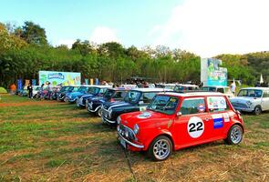 nakhon ratchasima, thailand - december 6, 2023 många gammal klassisk mini austin tunnbindare parkerad på gräs fält med grön träd och blå himmel bakgrund på bonanza khao jaja, nakhon ratchasima, thailand. foto