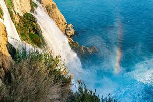 regnbåge på de fot av en vattenfall faller in i de hav från en klippa, lägre duden, antalya foto