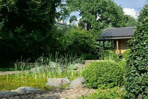 japansk trädgård med en damm och en te hus foto