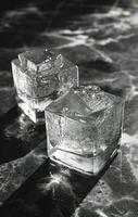 ai genererad två is kuber i en glas med whisky foto